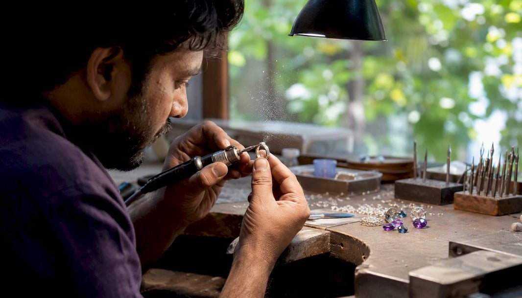 Jeweler filing metal ring in workshop