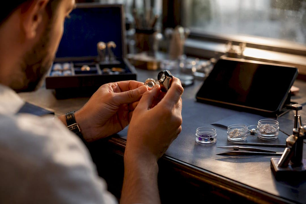 Hands inspecting ring details with jeweler's loupe